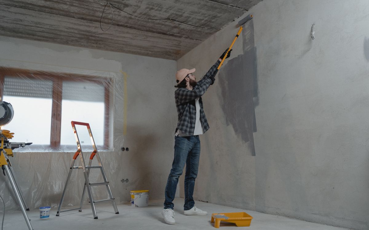 Painter cutting in a wall with a brush